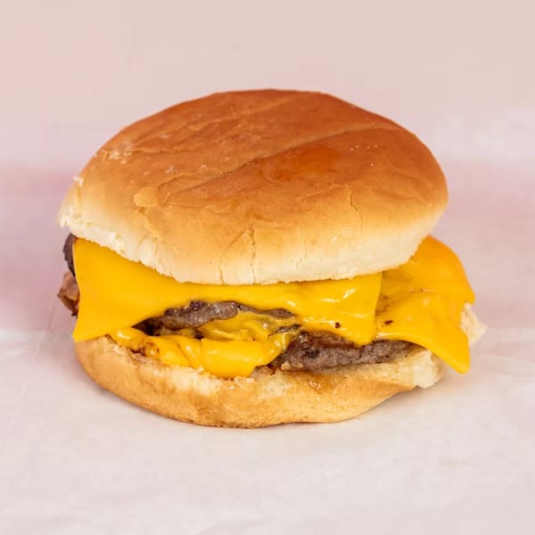 A double cheeseburger with melted yellow cheese and two patties on a toasted bun.
