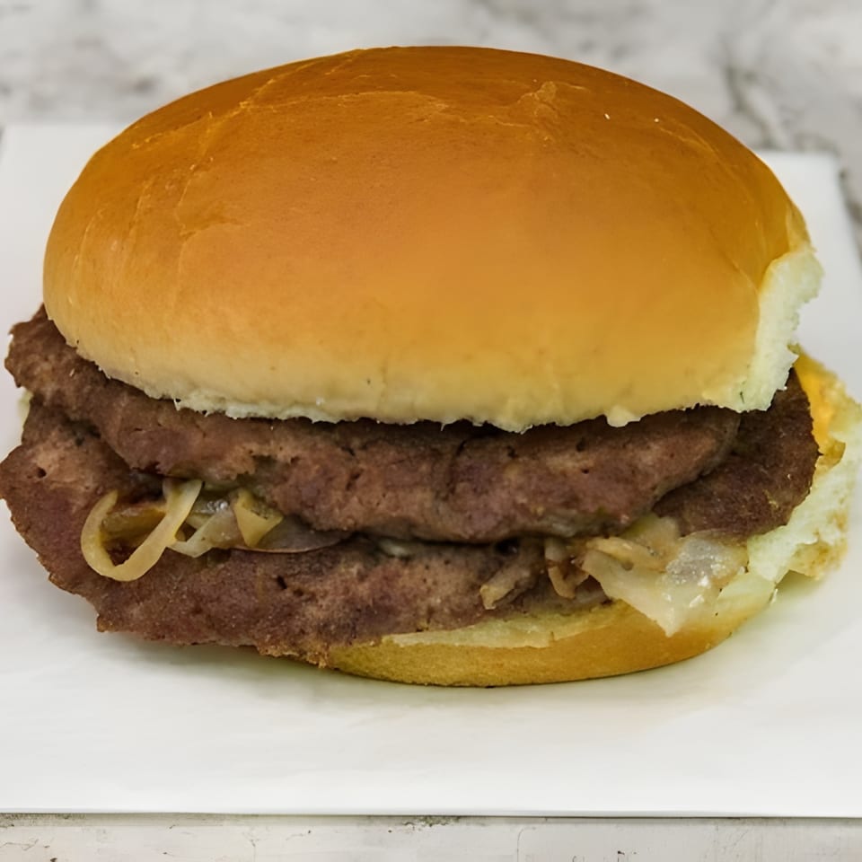 A double patty burger with caramelized onions and cheese on a white bun.
