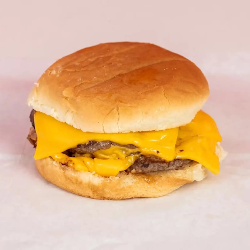 A double cheeseburger with melted yellow cheese and two patties on a toasted bun.