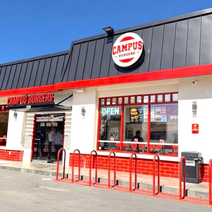 Exterior of Campus Burgers restaurant with red and white facade, black roof, and an "OPEN" sign.
